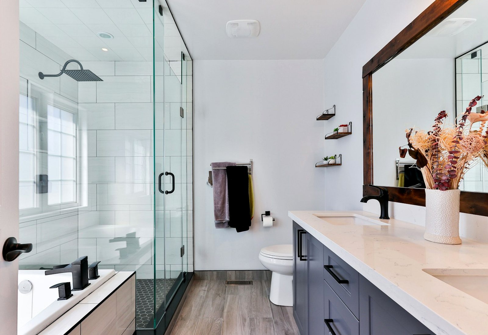 Clean tiled bathroom with a glass shower, vanity and grout lines